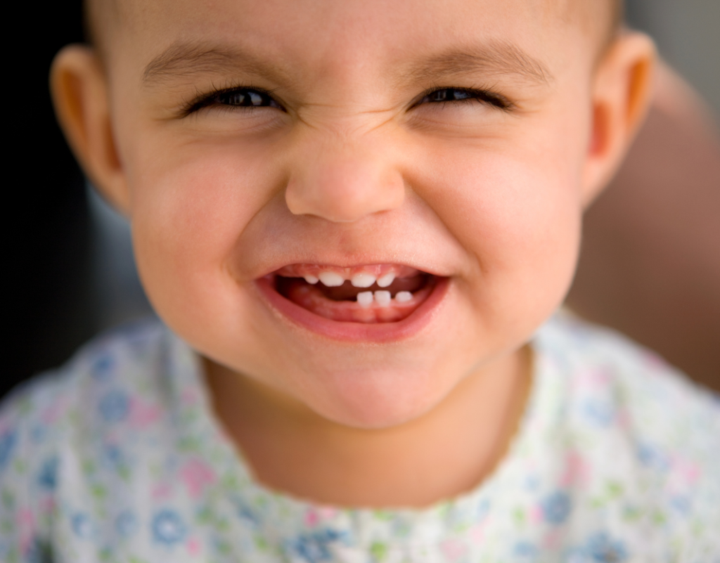 Bebe sonriendo con sus primeros dientes de leche